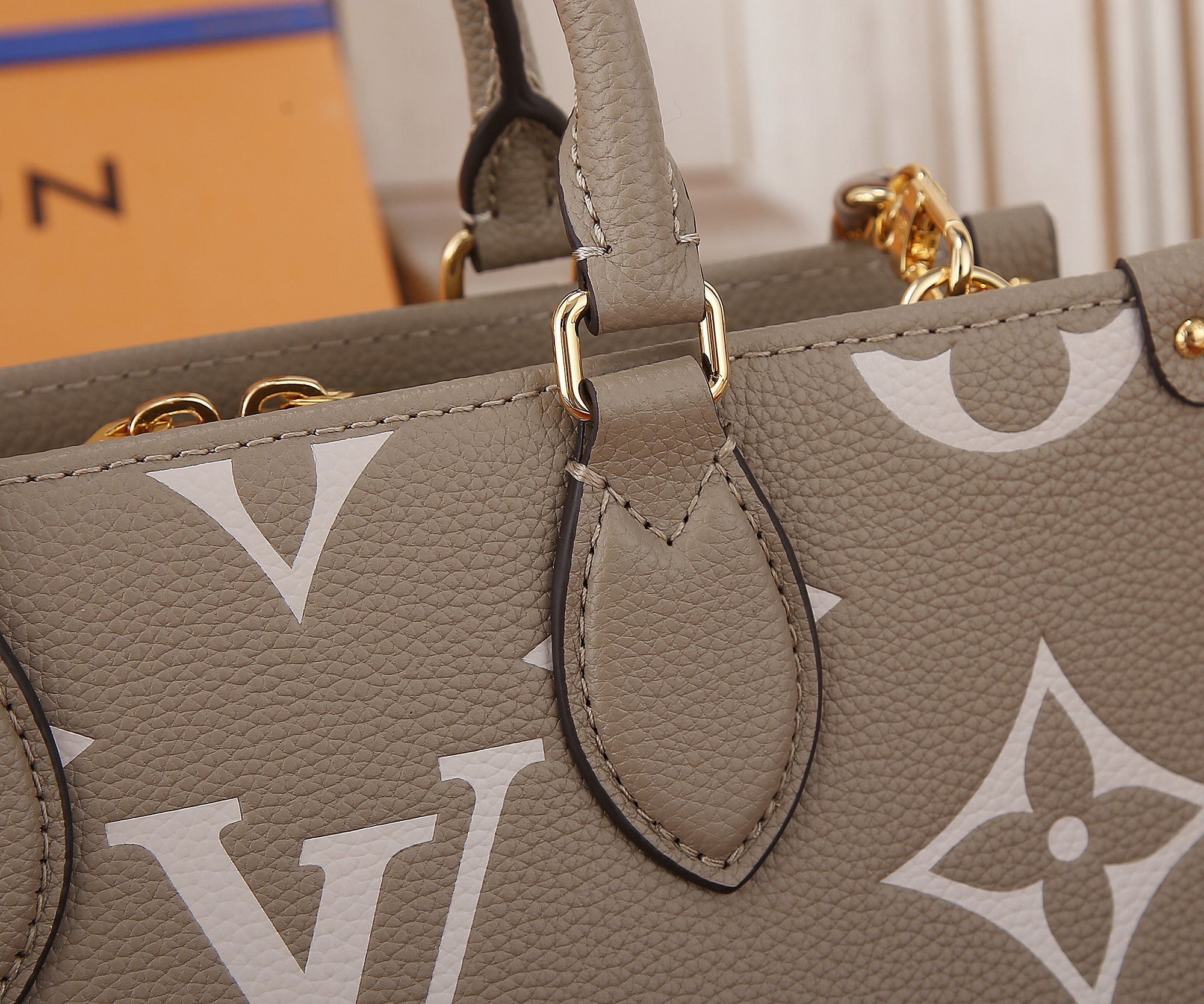 Onthego East West Chain Bicolor Monogram Empreinte Leather Dove/Cream M23641