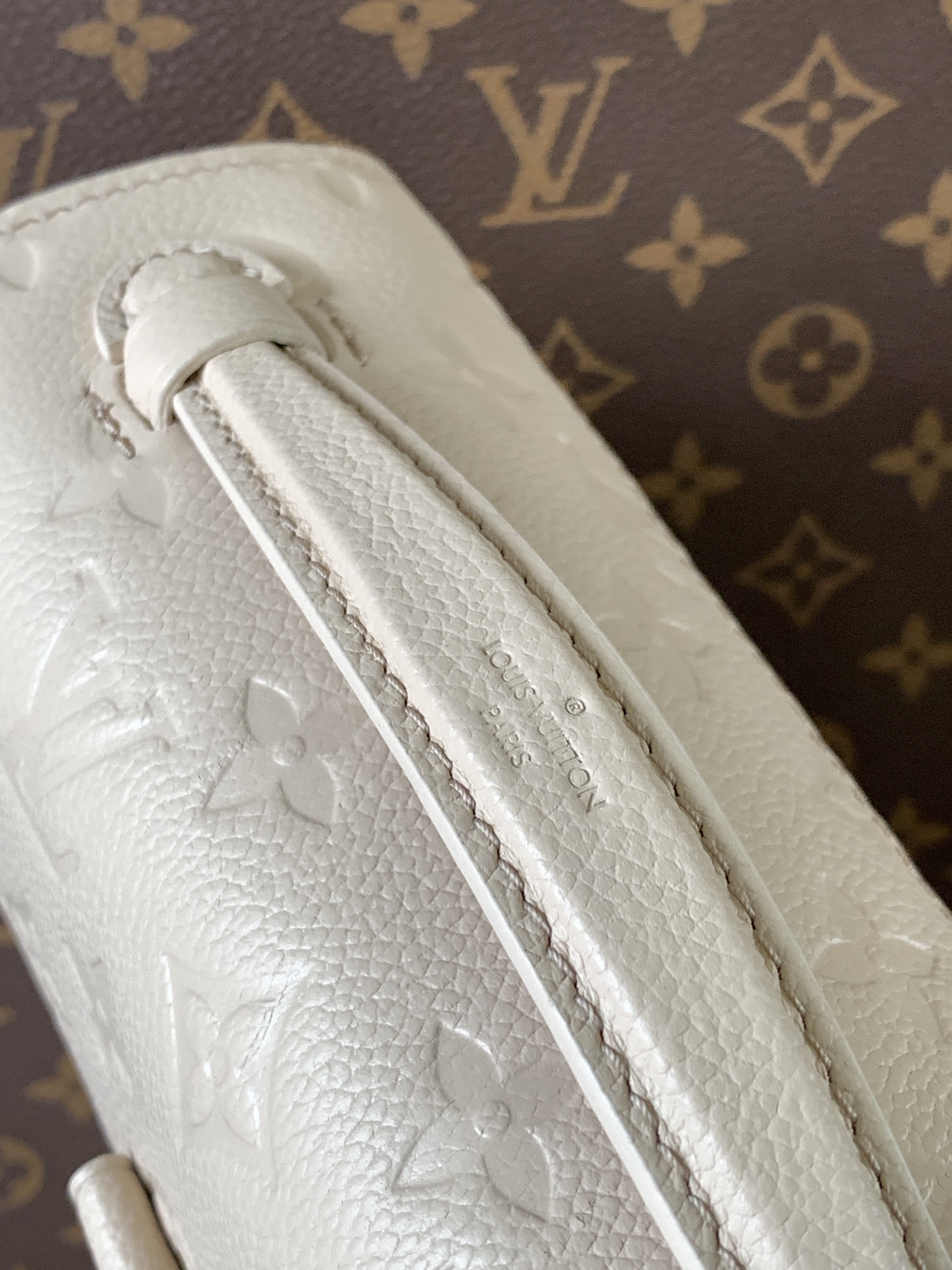 Pochette Métis East West Bag Monogram Empreinte Leather Cream M22942